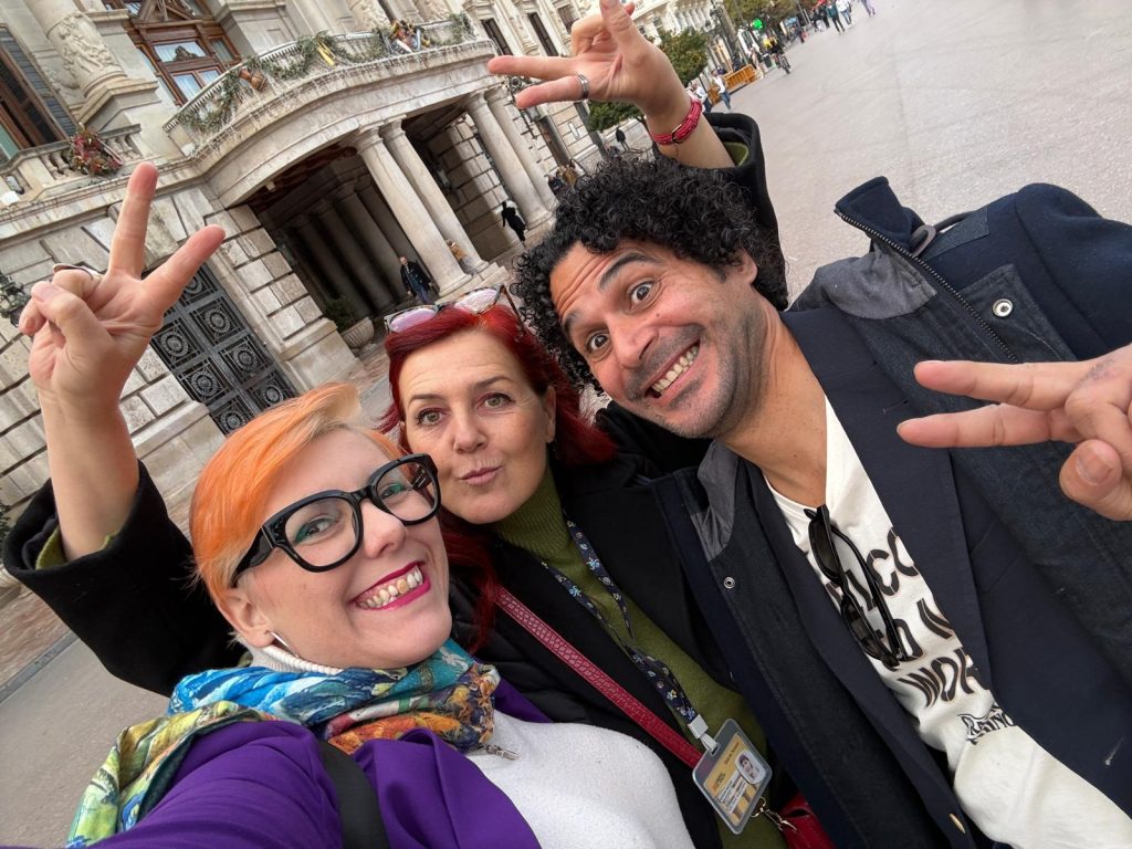 Grupo de amigos haciendo selfie en Barcelona, disfrutando del turismo y la cultura en la ciudad. Personas felices con expresiones de alegría, en un entorno urbano con arquitectura histórica.