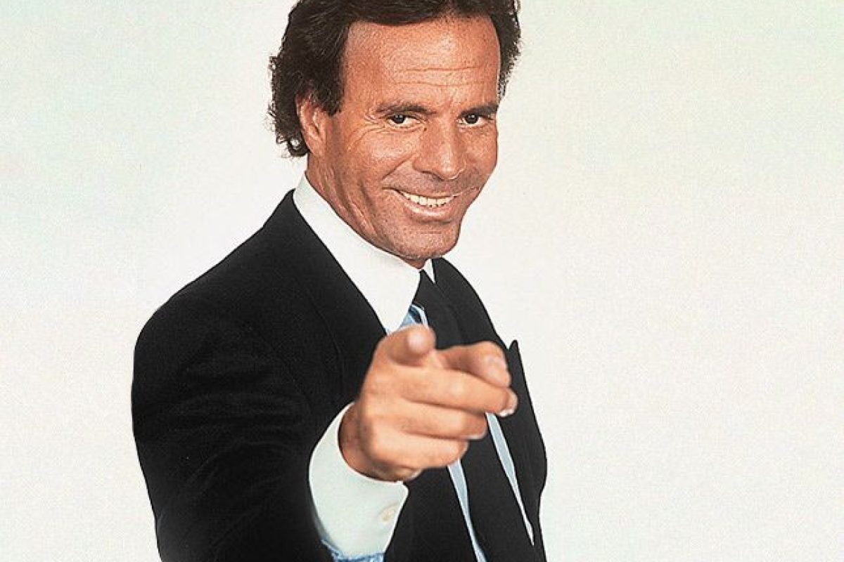 Hombre de negocios en traje con actitud confiada en fondo blanco, representando éxito y persuasión.