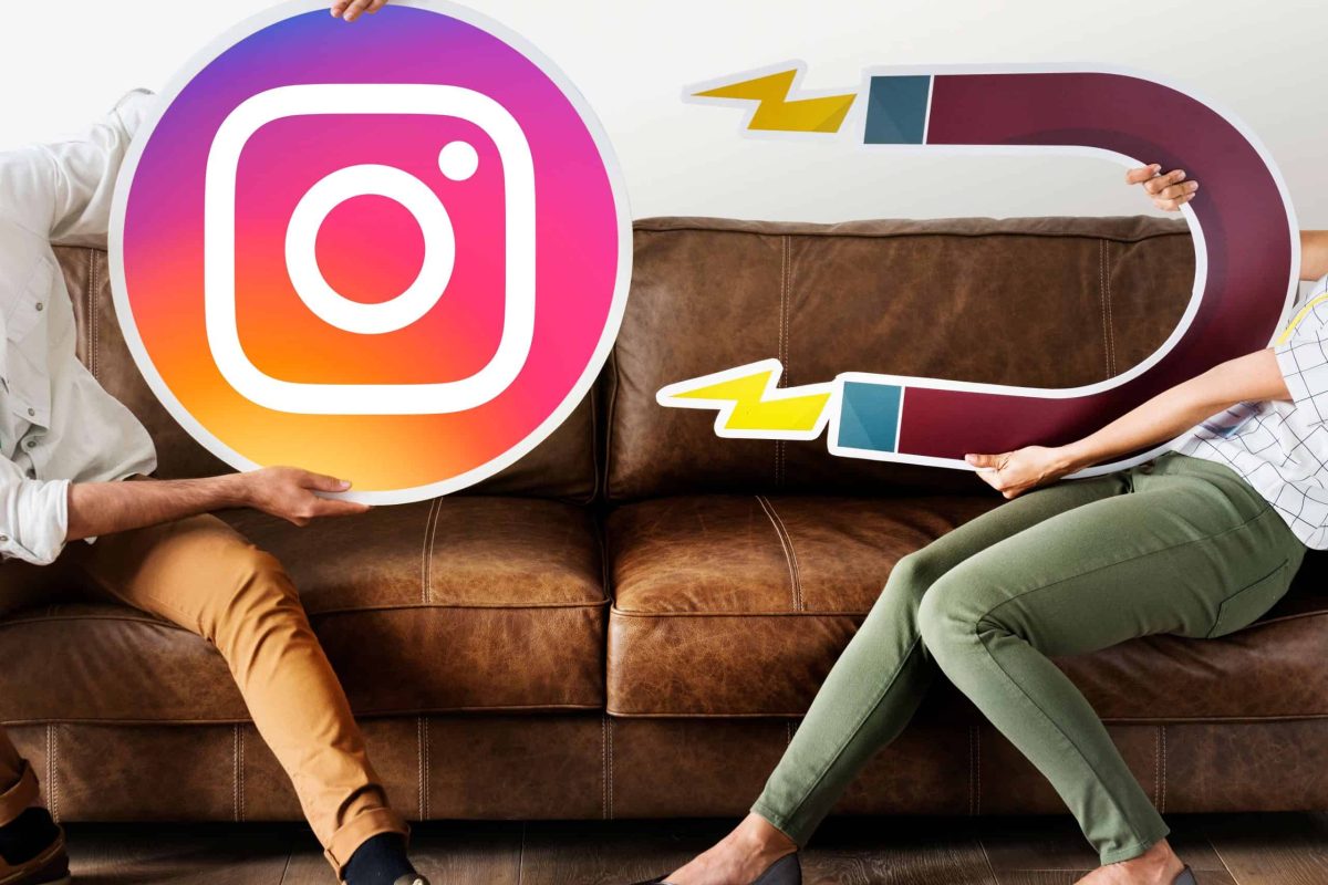 Dos personas sentadas en un sofá sujetando grandes iconos de cartón, uno con el logotipo de Instagram y otro con un imán, simbolizando la atracción de seguidores y el crecimiento orgánico en redes sociales. Representa la idea de cómo aumentar visibilidad, alcance y engagement en Instagram mediante estrategias de contenido efectivas y coherentes. Imagen conceptual sobre marketing digital, redes sociales y atracción de audiencia, perfecta para artículos de branding, social media y crecimiento orgánico. Palabras clave: crecer en Instagram, atraer seguidores, marketing digital, engagement, estrategia Instagram 2025, Tu Creativa, redes sociales.